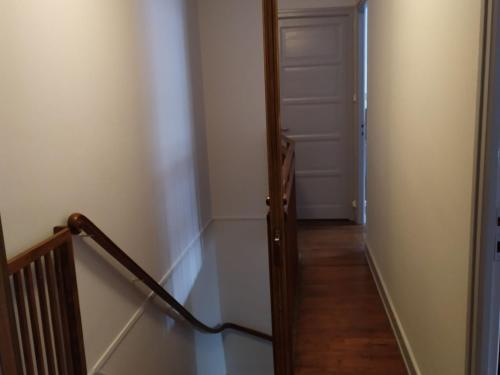 a hallway with a stairway leading to a white door at Gîte convivial avec 3 chambres, proche du patrimoine historique, cour et équipements inclus - FR-1-589-38 in Aouze