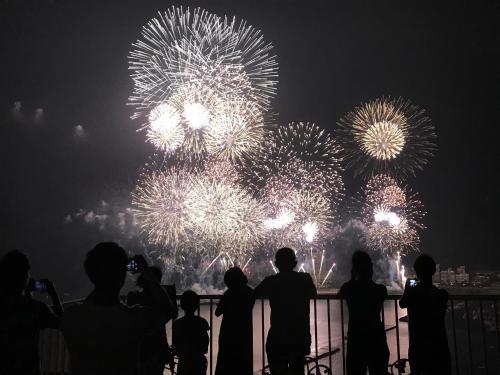 a group of people taking pictures of fireworks at Atami Onsen Guest House Megumi 5 minutes walk from Atami Station in Atami