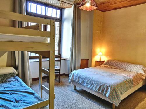 Un dormitorio con dos literas y una ventana. en Élégante maison de maître XVIIIe, jardin clos 500m², nature, proche Puy-en-Velay, 11 pers., cosy & confort - FR-1-582-315, en Arsac-en-Velay