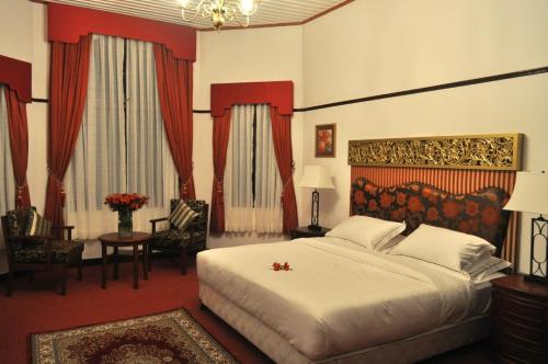 1 dormitorio con 1 cama grande, mesa y sillas en Royal Cocoon - Nuwara Eliya, en Nuwara Eliya