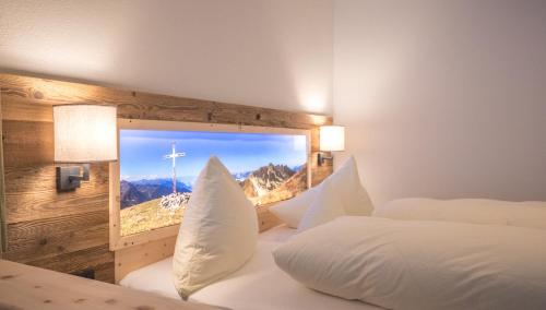 a bedroom with two beds and a window with a mountain view at Central Hotel & Apart mit Landhaus Central in Fügen