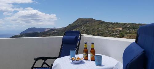 a table with bottles of beer and a bowl of food at Casa tra Cielo e Mare in Lipari