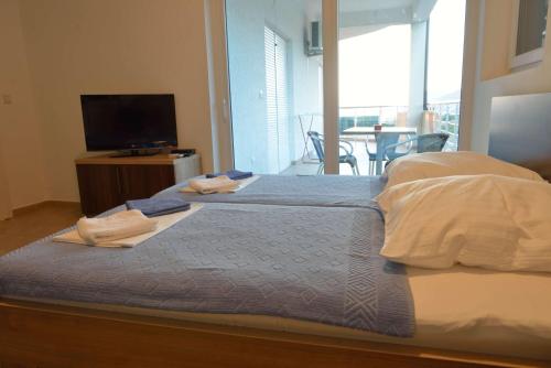Un dormitorio con una cama con dos toallas encima. en Belvedere Apartments with Seaview, en Dobra Voda