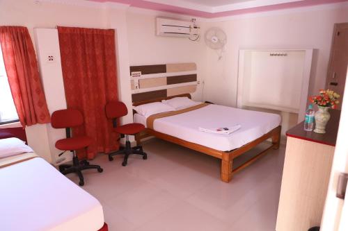 a hospital room with a bed and two chairs at Just Guest House, Chennai Airport in Chennai