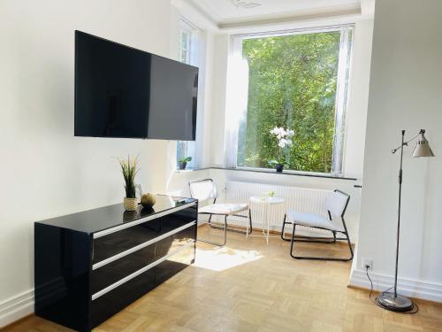 a living room with a flat screen tv on a wall at aday - Aalborg mansion - Open bright apartment with garden in Aalborg