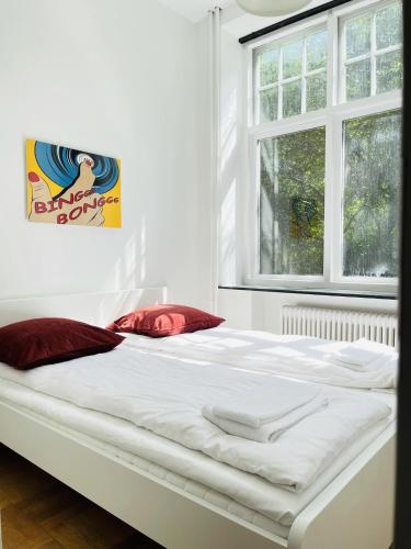a large white bed in a room with two windows at aday - Aalborg mansion - Open bright apartment with garden in Aalborg