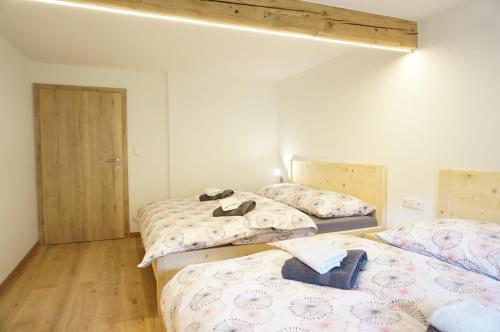 een slaapkamer met 2 bedden en schoenen erop bij Ferienwohnung Litzlhof in Itter