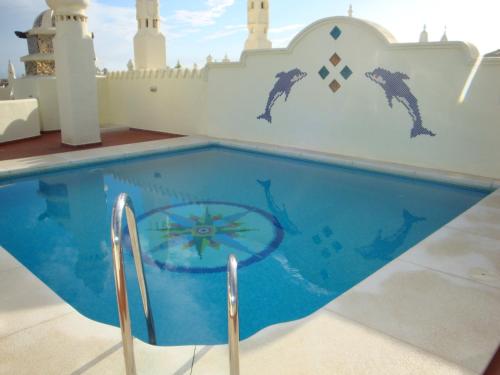 a swimming pool with dolphins painted on a wall at Capaldi Luxury Holiday Rentals Puerto Marina Benalmadena in Benalmádena
