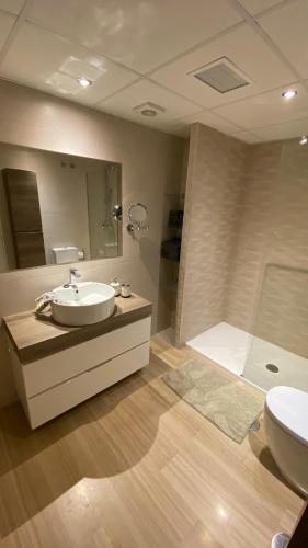 a bathroom with a sink and a mirror and a shower at Capaldi Luxury Holiday Rentals Puerto Marina Benalmadena in Benalmádena