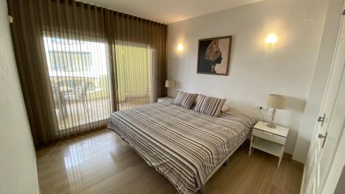 a small bedroom with a bed and a window at Capaldi Luxury Holiday Rentals Puerto Marina Benalmadena in Benalmádena