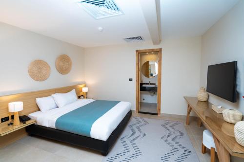 a bedroom with a bed and a flat screen tv at Redcon Suites in Hurghada