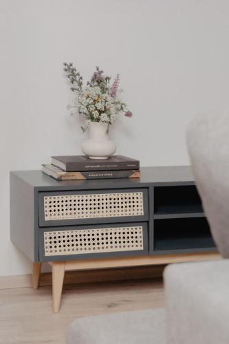 a table with a vase of flowers and books at mei chalet - DAS BARBARA in Leutasch