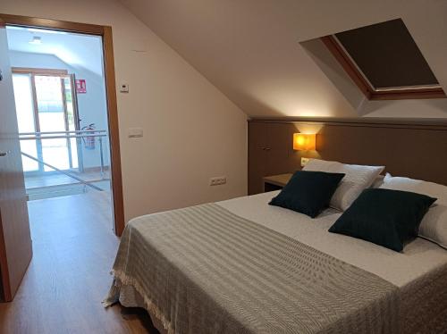 a bedroom with a large bed with green pillows at Albergue Hostel Nuestra Señora del Camino in Combarro