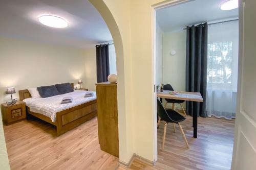 Schlafzimmer mit einem Bett, einem Tisch und einem Schreibtisch in der Unterkunft Peter's Market apartment in Liepāja