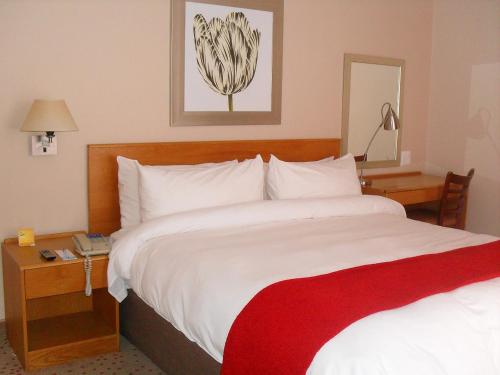 a hotel room with a large bed with a red blanket at Garden Court Nelson Mandela Boulevard in Cape Town
