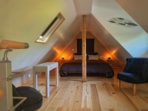 une chambre avec un lit dans un grenier dans l'établissement Le Pré Aux Loups, à Hautot-sur-Mer
