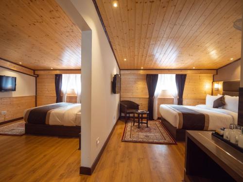 a hotel room with two beds and a desk at Sumitel Shangrila in Tādong