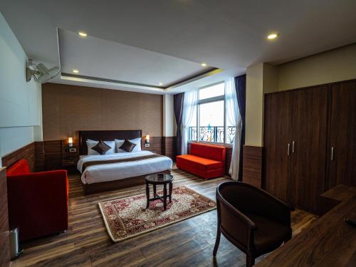 a hotel room with a bed and a red chair at Sumitel Shangrila in Tādong