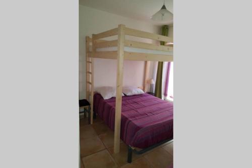 ein Schlafzimmer mit einem Etagenbett mit einer lila Tagesdecke in der Unterkunft Maison au centre de St Jean du Gard in Saint-Jean-du-Gard