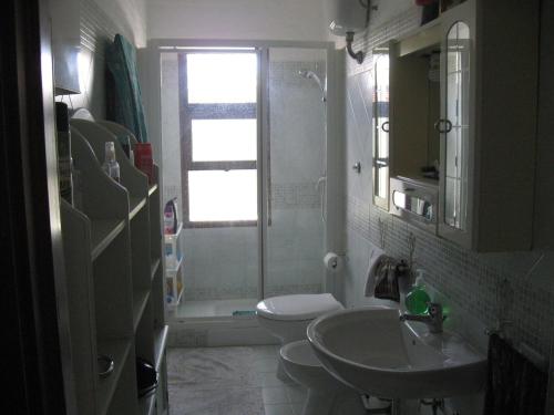 uma casa de banho com um lavatório, um WC e uma janela. em Appartamento Con Accesso Spiaggia em Pula