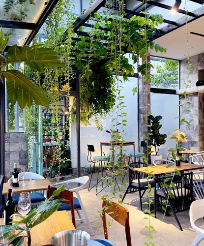 Un restaurante con mesas, sillas y plantas. en Côn Đảo House, en Con Dao