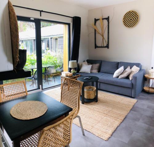 a living room with a couch and a table at Appartement Beau Séjour - Accès Piscine in Criel-sur-Mer
