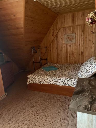 a bedroom with a bed in a wooden room at Садиба Зґарда in Yaremche