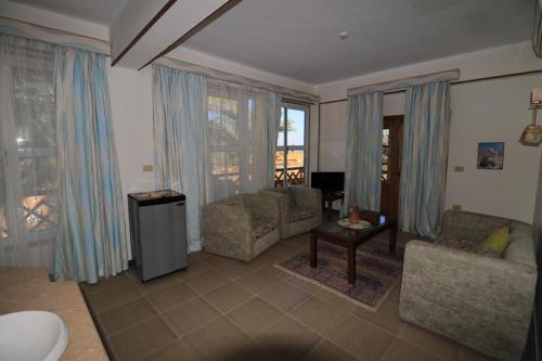a living room with a couch and chairs and windows at Acacia Dahab Hotel in Dahab