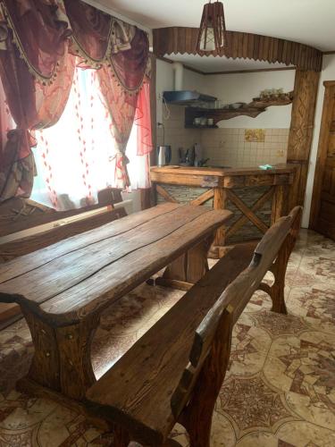 a large wooden table in a kitchen with a window at Садиба Зґарда in Yaremche