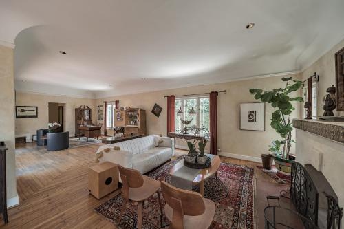 a living room with a white couch and a fireplace at 1925 Spanish Villa Retreat near Disneyland in Historic Park Santiago home in Santa Ana