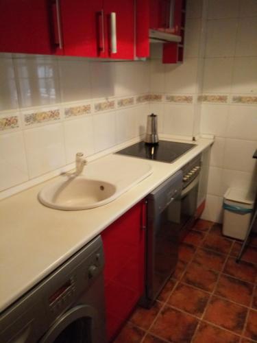 a kitchen with a sink and red cabinets at Ávila Flats Pz Ejército Avila in Ávila