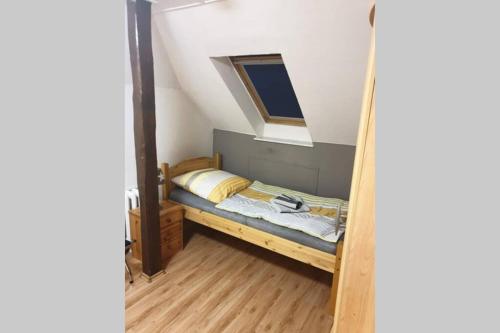 Dormitorio pequeño con cama en el ático en Große Gästewohnung Böllstorf GbR (mit Klimaanlage), en Osterburg Siedlung