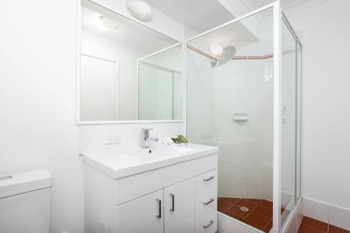 a white bathroom with a sink and a shower at Nautica Residences Hillarys in Perth