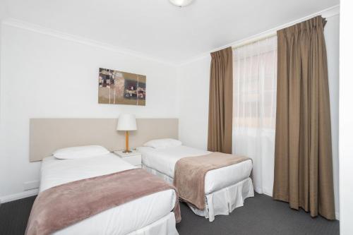 a hotel room with two beds and a window at Nautica Residences Hillarys in Perth