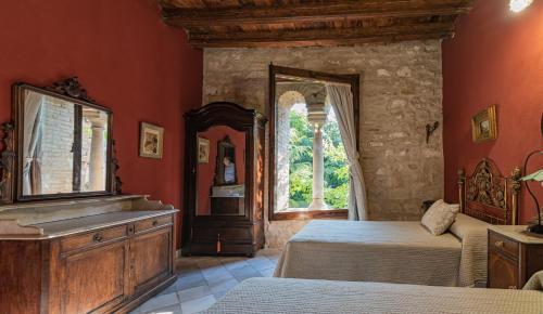 a bedroom with a bed and a dresser and a window at Casa Palacio el Caballero de Malta in Úbeda