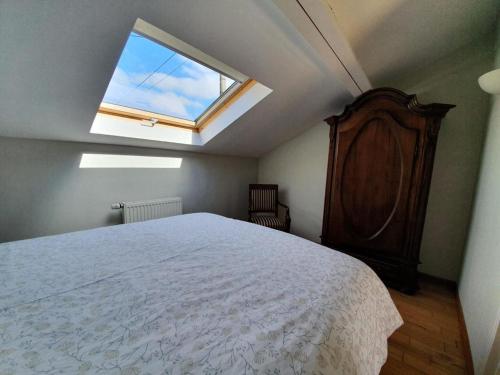 a bedroom with a large bed with a window at Le Maissin 1876 in Paliseul
