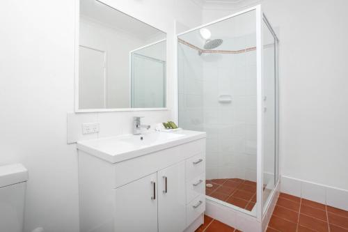 a white bathroom with a sink and a shower at Nautica Residences Hillarys in Perth