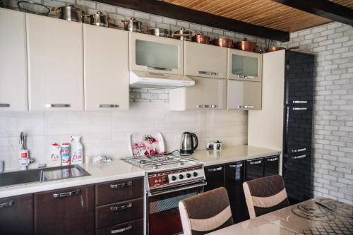 a kitchen with white cabinets and a stove top oven at Стежка в гори in Verkhovyna