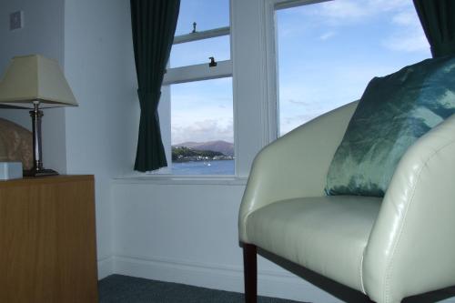 a white chair sitting in a room with a window at The Victoria Hotel in Rothesay