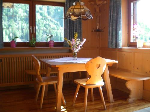 カステルロットにあるSchiedhofの木製テーブル(椅子2脚付)と花瓶