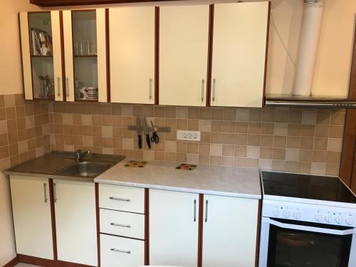 a kitchen with white cabinets and a sink and a stove at AMAZING SEA VIEW Guest House ADRIATICA in Kotor