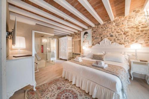 a bedroom with a large bed and a stone wall at Regia Rosetta - Royal Rooms Borghetto in Valeggio sul Mincio