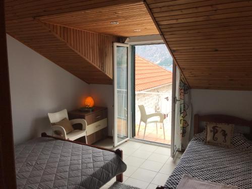 a bedroom with a bed and a balcony with a window at AMAZING SEA VIEW Guest House ADRIATICA in Kotor