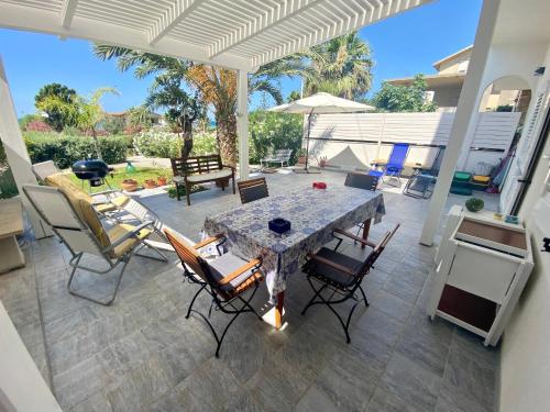 eine Terrasse mit einem Tisch und Stühlen auf einer Terrasse in der Unterkunft VILLA OASI a 50 mt dalla spiaggia in Alcamo Marina