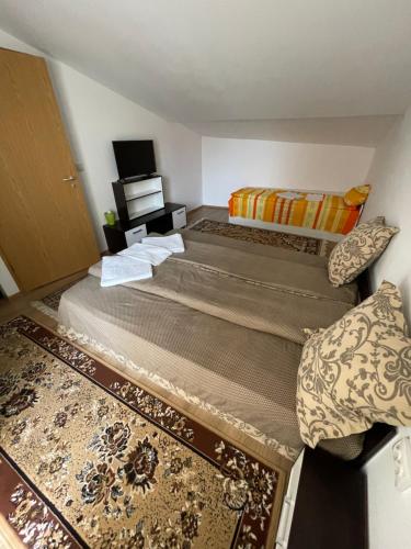 two beds in a small room with a tv at Casa Wiesmann Băile Felix in Baile Felix
