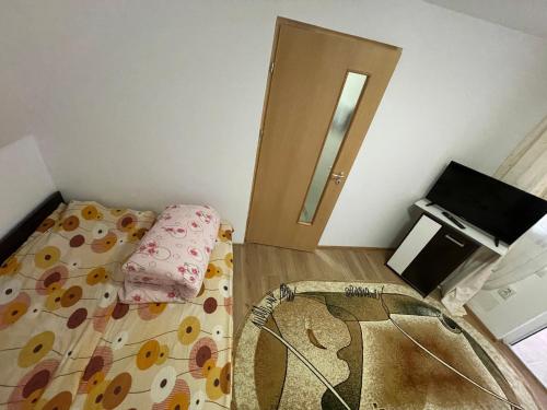 a small bedroom with a bed and a door at Casa Wiesmann Băile Felix in Baile Felix