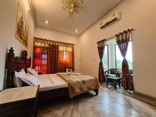 a bedroom with a bed and a chair in a room at Hotel Green Haveli - A Heritage and Hill View Hotel , Pushkar in Pushkar