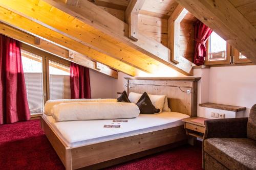 ein Schlafzimmer mit einem Bett in einem Zimmer mit Holzdecken in der Unterkunft Hotel Garni Lawens in Serfaus