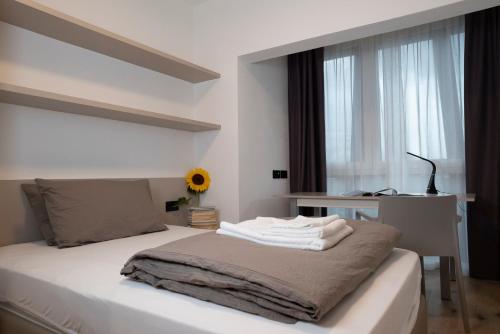 a bedroom with a bed with white sheets and a window at SILVANELLO Apartment in Trento