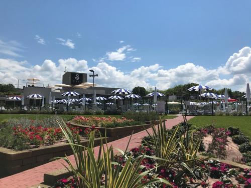 un giardino con ombrelloni e fiori in un parco di Sisan Family Resort a Bardolino
